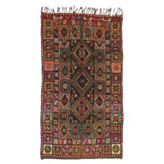 an old rug with fringes on the edges and colorful designs in red, green, orange