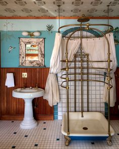 an old fashioned bathtub in a bathroom with blue walls and white tile flooring