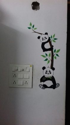 a panda bear on a tree is painted on the wall next to a light switch