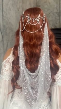 a woman with long red hair wearing a veil