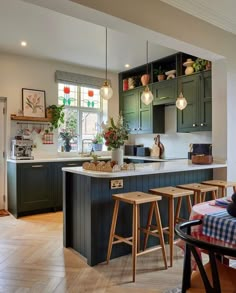 a kitchen filled with lots of counter space and wooden stools next to an island