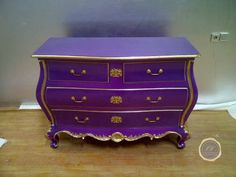 a purple dresser sitting on top of a wooden floor