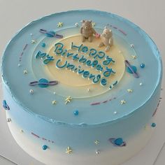 a blue and white birthday cake with two bears on top