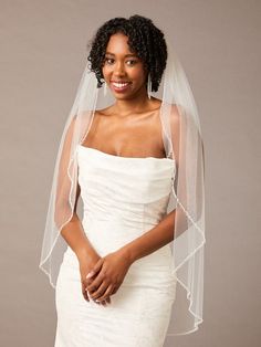 a woman wearing a white wedding dress and veil