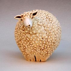 a sheep figurine made out of clay on a white surface with grey background