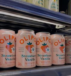 six cans of strawberry vanilla drink on display in a grocery store or convenience store shelf