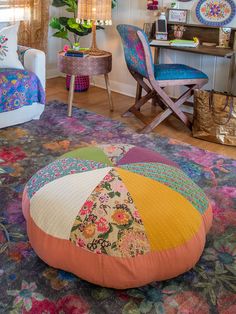 a living room filled with lots of furniture and colorful pillows on top of a rug