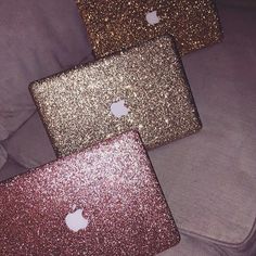 three laptops sitting on top of a couch covered in pink and gold glitter fabric