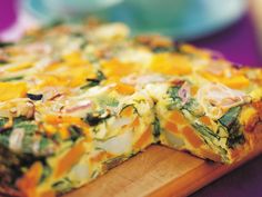 a close up of a pizza on a cutting board with cheese and other toppings