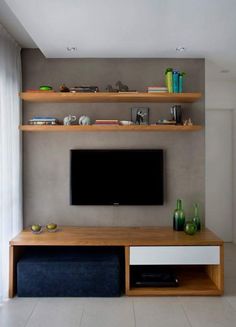 a flat screen tv sitting on top of a wooden shelf