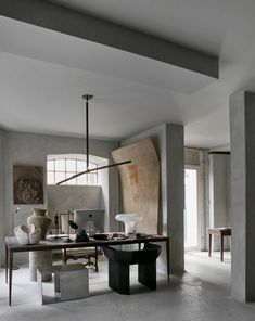 a room with a desk, chair and vases on the table in front of it