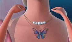 a woman wearing a butterfly necklace with pearls on her neck and hands behind her back