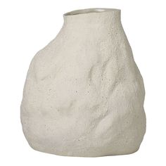 a white vase sitting on top of a table