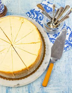 a cheesecake sitting on top of a white plate next to a knife and fork