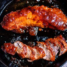 two pieces of meat cooking in a skillet