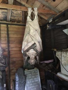 statues in a wooden room with wood paneling and exposed ceiling, including a statue of a woman draped over her head