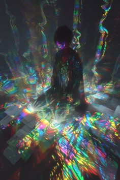 a person sitting in the middle of a room with colorful lights on it's floor