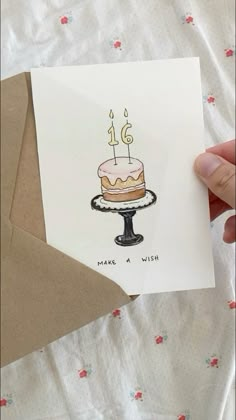 a hand holding up a card with a cake on it