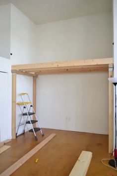 an unfinished room with ladders and construction materials on the floor in front of it