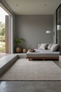 a living room with a couch, table and large window overlooking the outside area in front of it