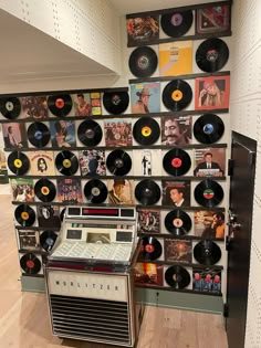 an old record player sitting in front of a wall with records on it's sides