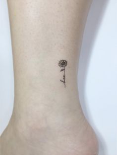 a woman's foot with a small flower tattoo on her left side calfocks