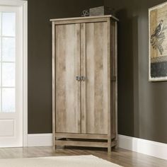 a tall wooden cabinet sitting in a living room next to a white rug on the floor