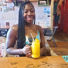 a woman sitting at a table with a glass of orange juice