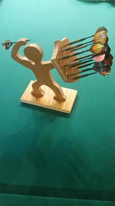 a wooden sculpture of a man with many arrows in his hand on a table top