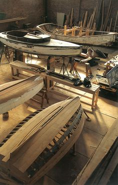 several canoes are being worked on in a workshop