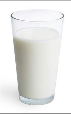 a glass filled with milk sitting on top of a table