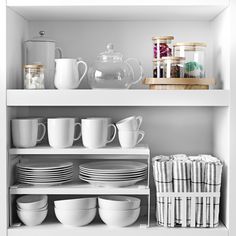 the shelves are filled with dishes and cups