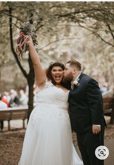 a bride and groom pose for a photo in the park