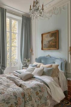 a bedroom with a chandelier hanging from the ceiling and a bed in front of a window