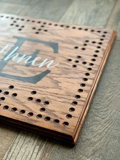 a wooden board with holes and the word hope written in white ink on it, sitting on a wood floor