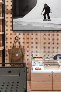 a man riding a skateboard on top of a wooden shelf next to a bag