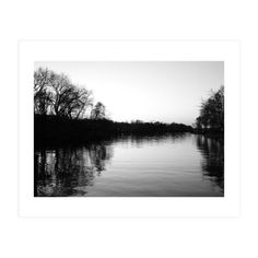 black and white photograph of water with trees in the background