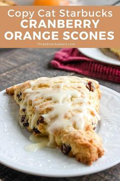 an orange scones on a white plate with icing and cranberries in the background