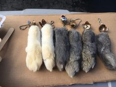 four different colored fur key chains on a cardboard box next to other animal's accessories