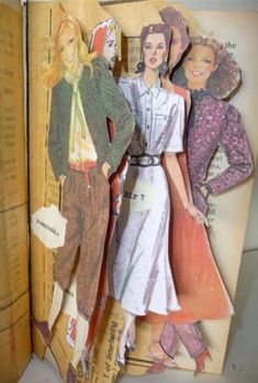 an open book with paper cutouts of women in dresses and hats on it's pages