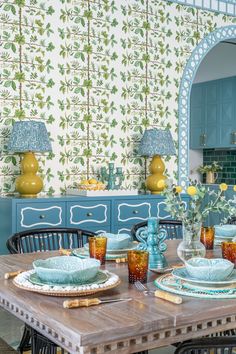 a dining room table with plates and cups on it