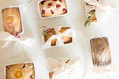 several different types of baked goods wrapped in cellophane and tied with white ribbons