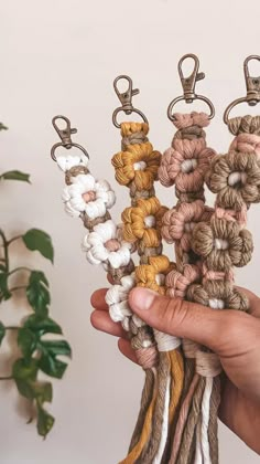 a person holding several different colored crochet key chains in their left hand and the other two are made from yarn