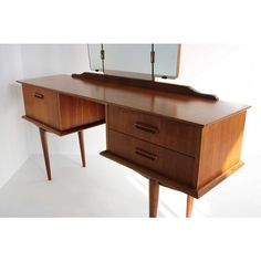 a wooden desk with two drawers and a mirror