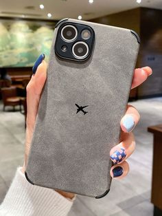 a woman holding up her phone case with an airplane sticker on the back cover