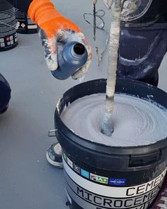 a person is pouring cement into a bucket