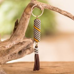 a close up of a piece of jewelry on a wooden table with a tree branch in the background