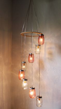 a chandelier with mason jars hanging from it's sides in a room