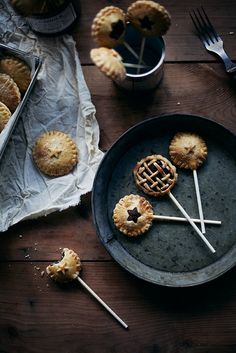 small pastries on sticks in a metal pan with napkins and spoons next to them