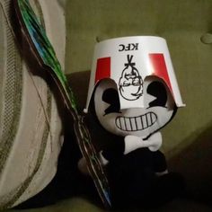 a close up of a toothbrush and a cup on a couch with a cartoon character